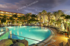 Vista general nocturna de la piscina principal y el hotel