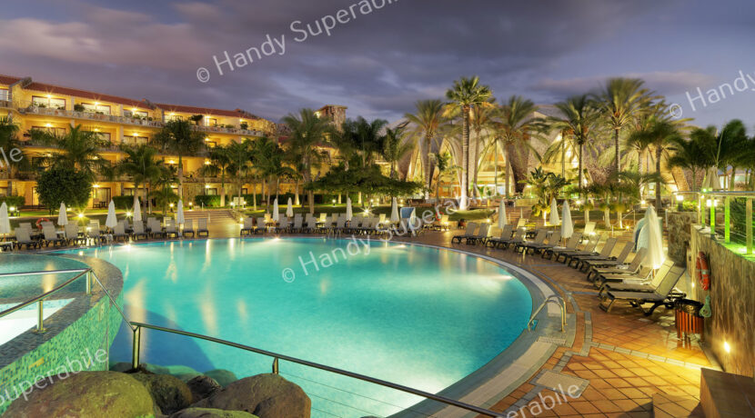 Vista general nocturna de la piscina principal y el hotel